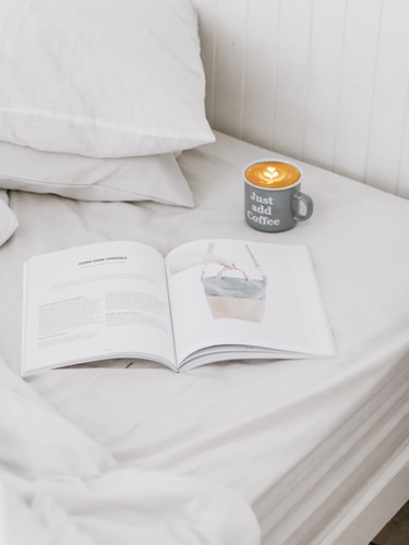 Bed met een boek en koffie